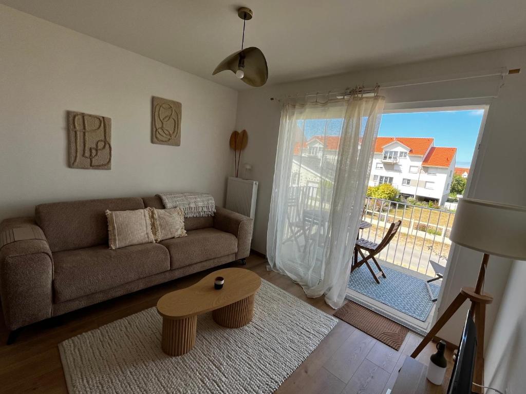 a living room with a couch and a table at At Home Ste Cécile in Camiers