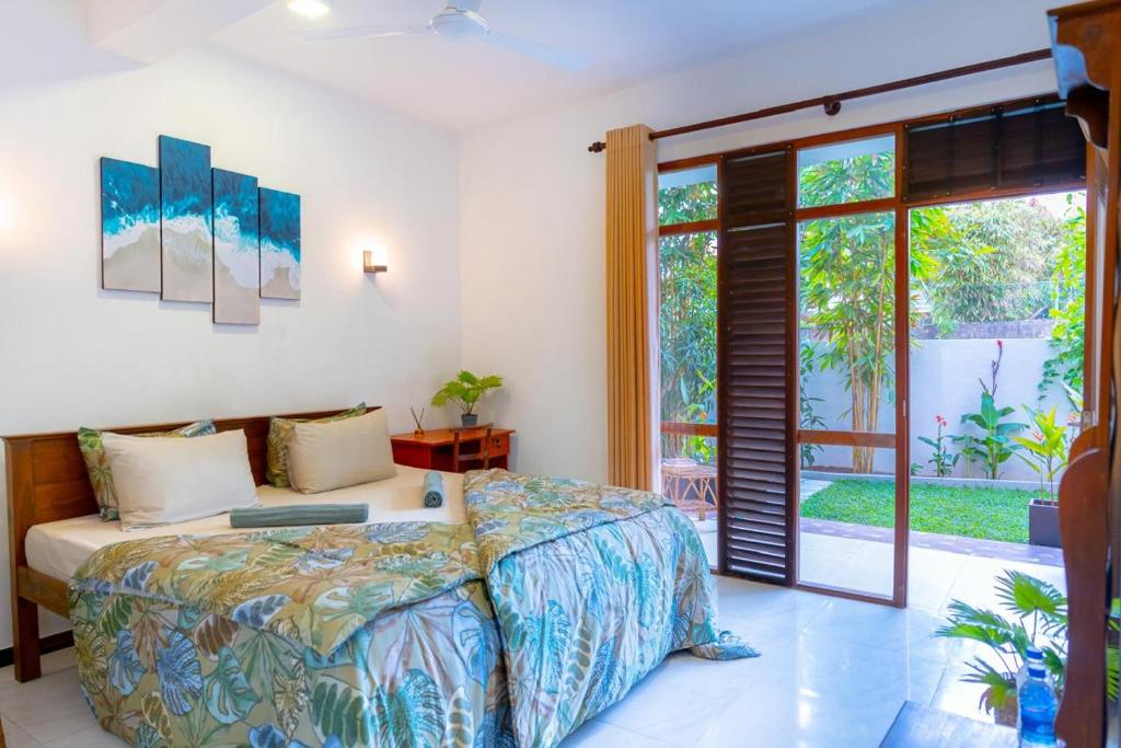 a bedroom with a bed with a laptop on it at Villa Pisangra in Matara