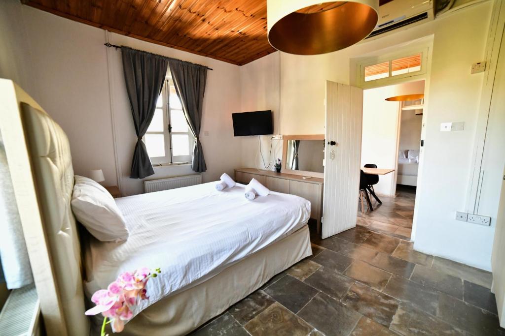 a bedroom with a white bed and a window at Laouri Traditional 2-Bedroom in Kalopanayiotis in Kalopanayiotis