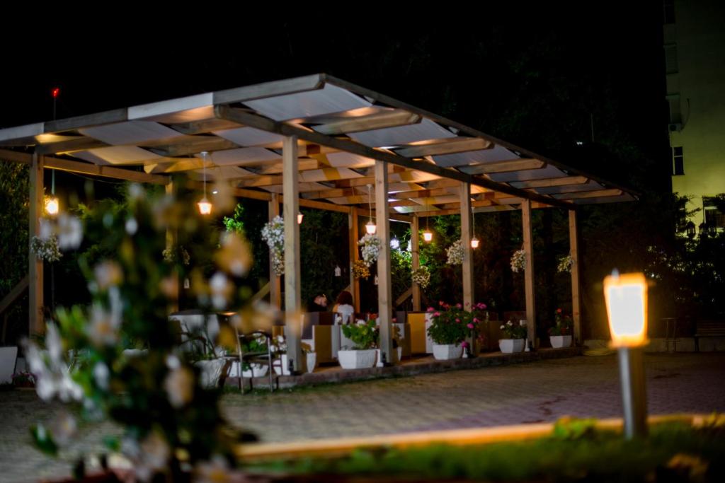 - un pavillon avec une table, des chaises et des fleurs dans l'établissement Kadrisa Hotel, à Durrës