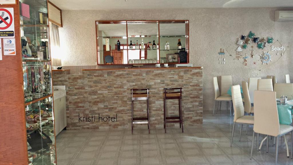 a restaurant with a bar with stools in a room at Kristi in Póros Kefalonias