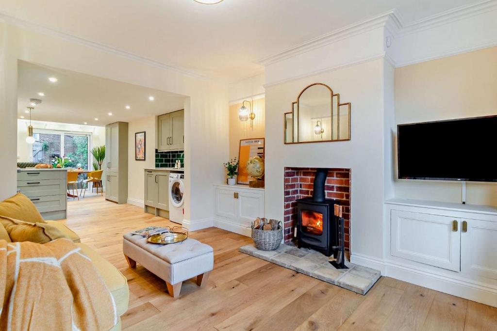 ein Wohnzimmer mit Kamin und Fernseher in der Unterkunft Cornfield Terrace in Southwold