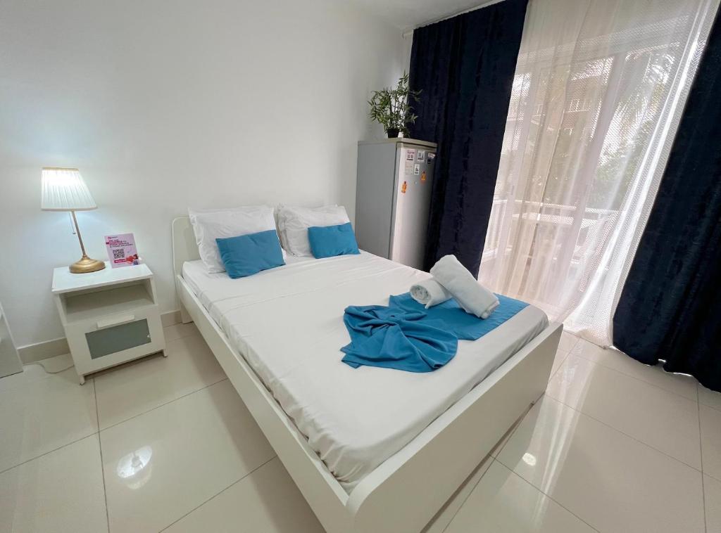 Un dormitorio con una cama con almohadas azules y una ventana. en Good location Good price, en Punta Cana