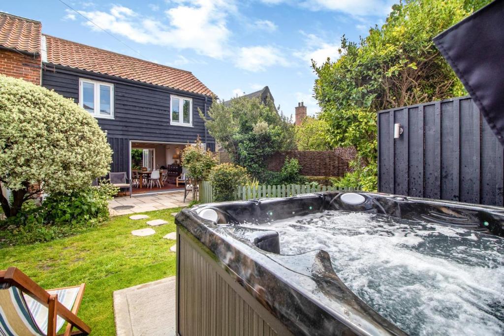 a hot tub in the backyard of a house at Vine Cottage in Walberswick