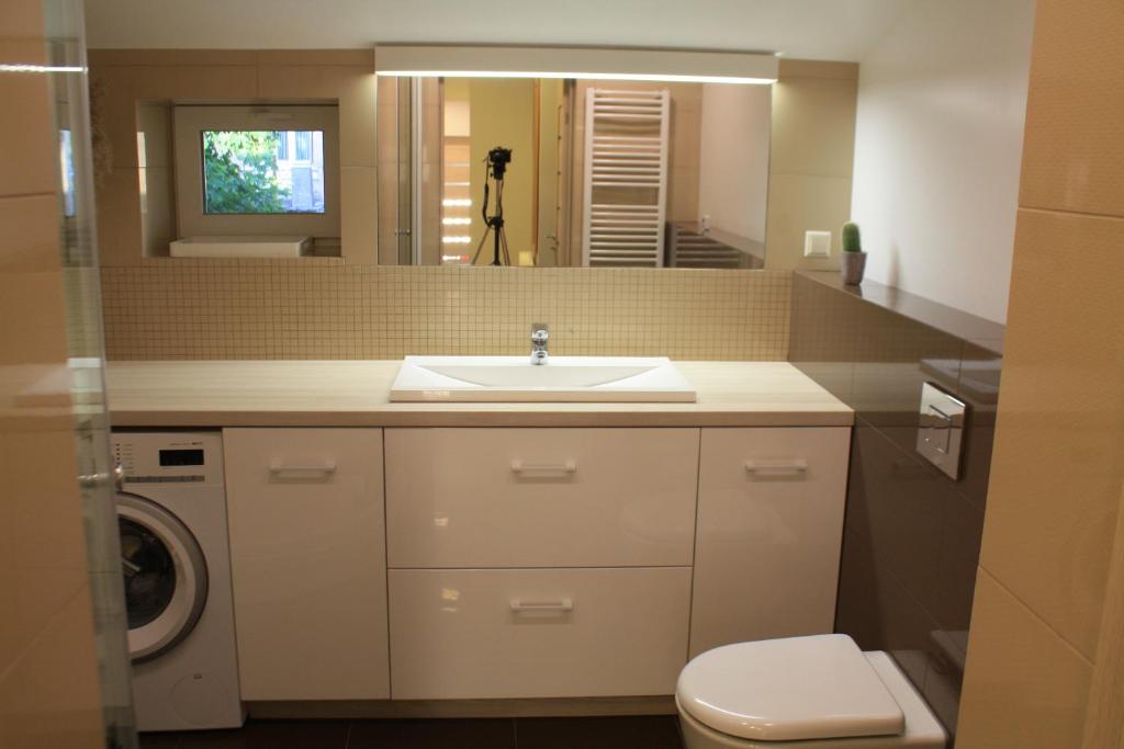 un bagno con lavandino, WC e specchio di S11 a Palanga