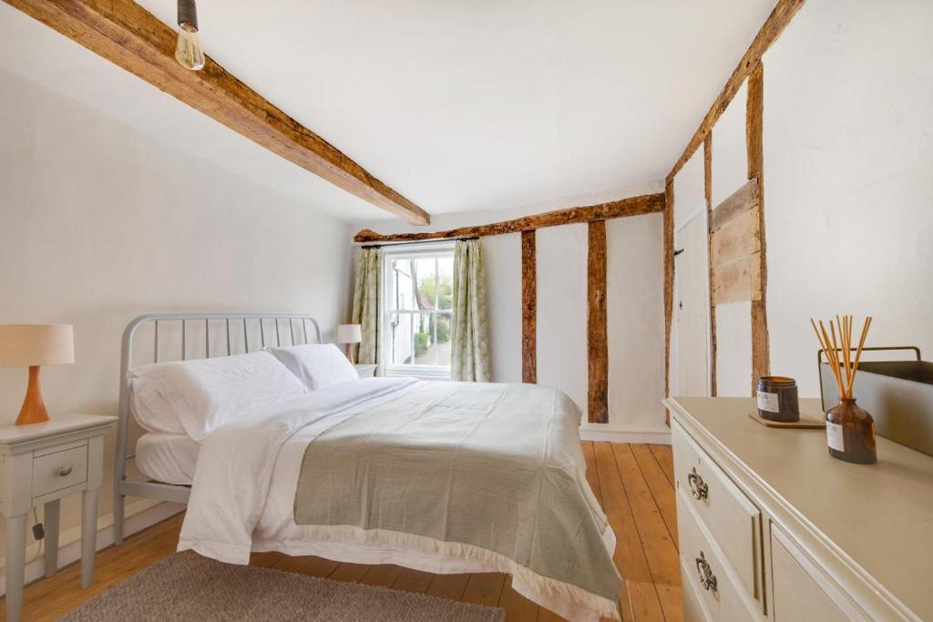 a bedroom with a white bed and a window at London Cottage in Halesworth
