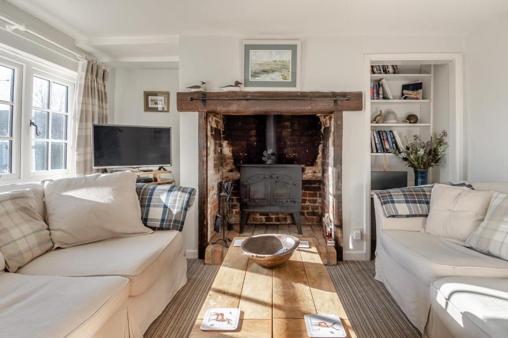 a living room with a couch and a fireplace at Alde Cottage in Friston