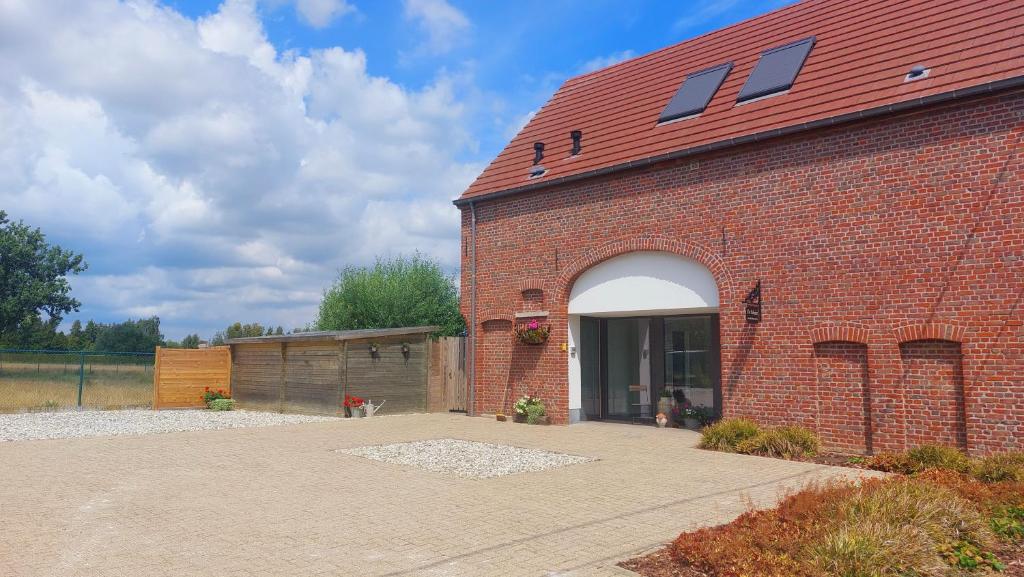 a red brick building with a large doorway at Vakantiewoning De Schuur Tienen in Tienen