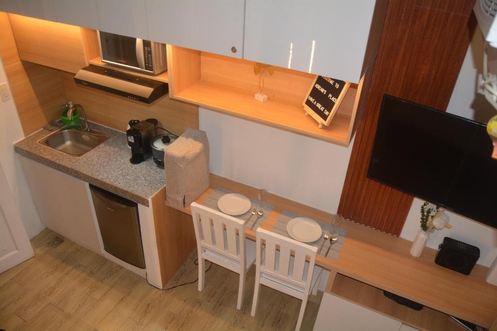 eine kleine Küche mit einem Tisch und zwei Stühlen in der Unterkunft Adrian's Place at La Bella Tagaytay in Galicias