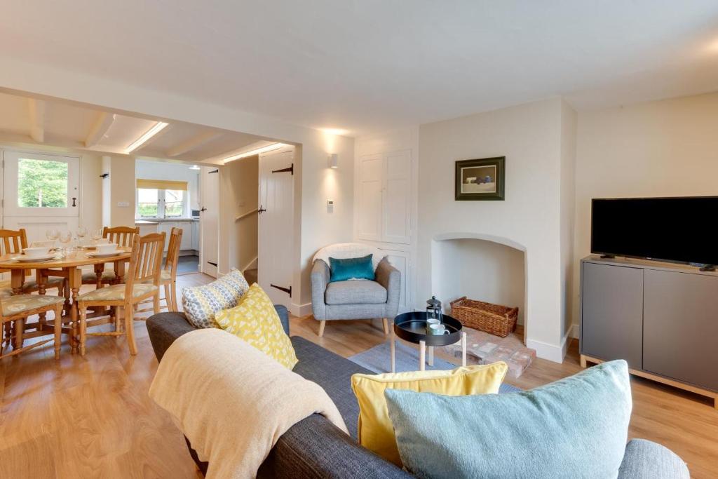 Japonica Cottage في Wenhaston: غرفة معيشة بها أريكة وطاولة