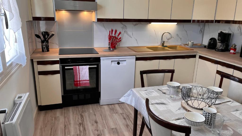 a kitchen with a table and a stove top oven at La Parenthèse in Longchaumois