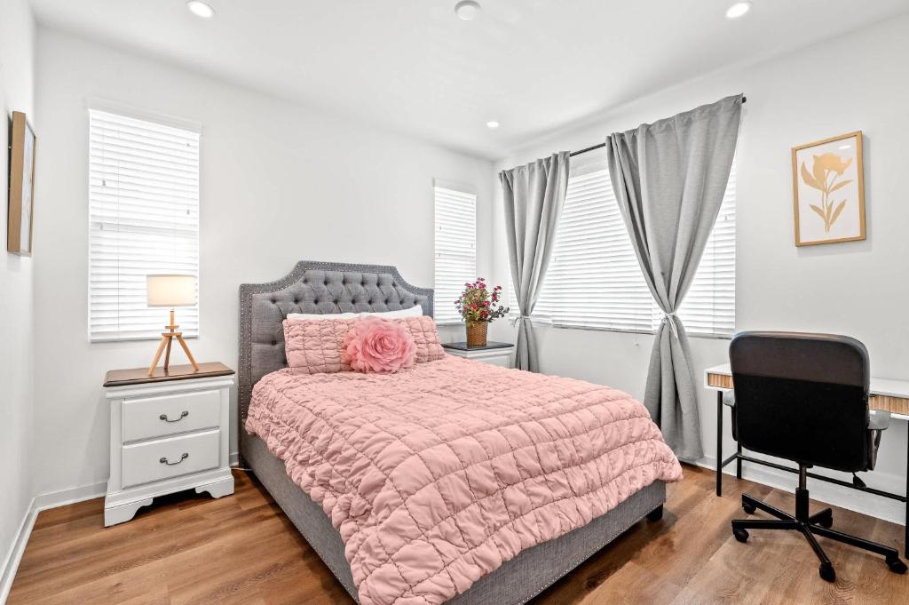 Schlafzimmer mit einem rosa Bett, einem Schreibtisch und einem Stuhl in der Unterkunft Central Location Cozy Private Bedroom w Bathroom in Irvine