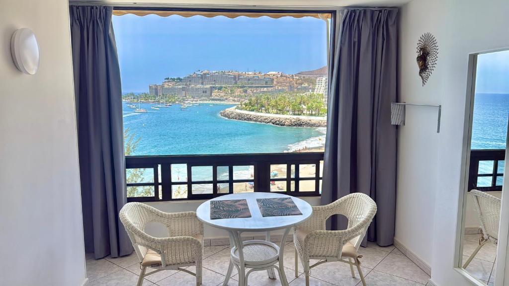 a table and chairs in a room with a view of the ocean at Doñana 16 in Patalavaca