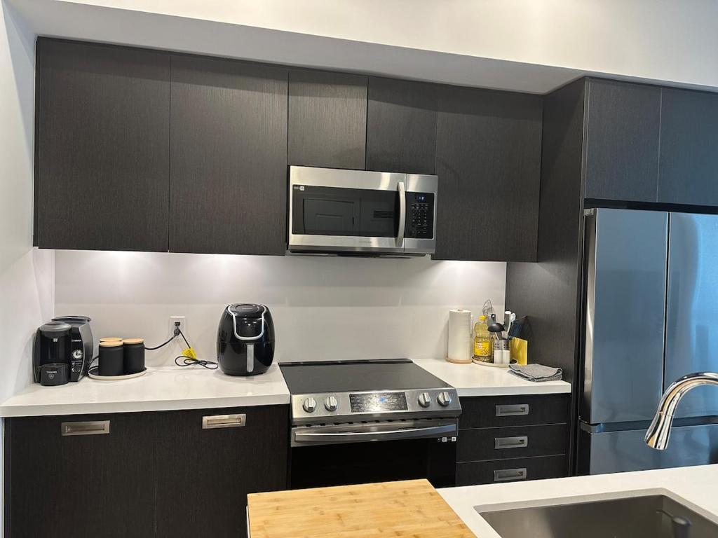 a kitchen with black cabinets and a microwave at Friday Harbour Resort in Innisfil