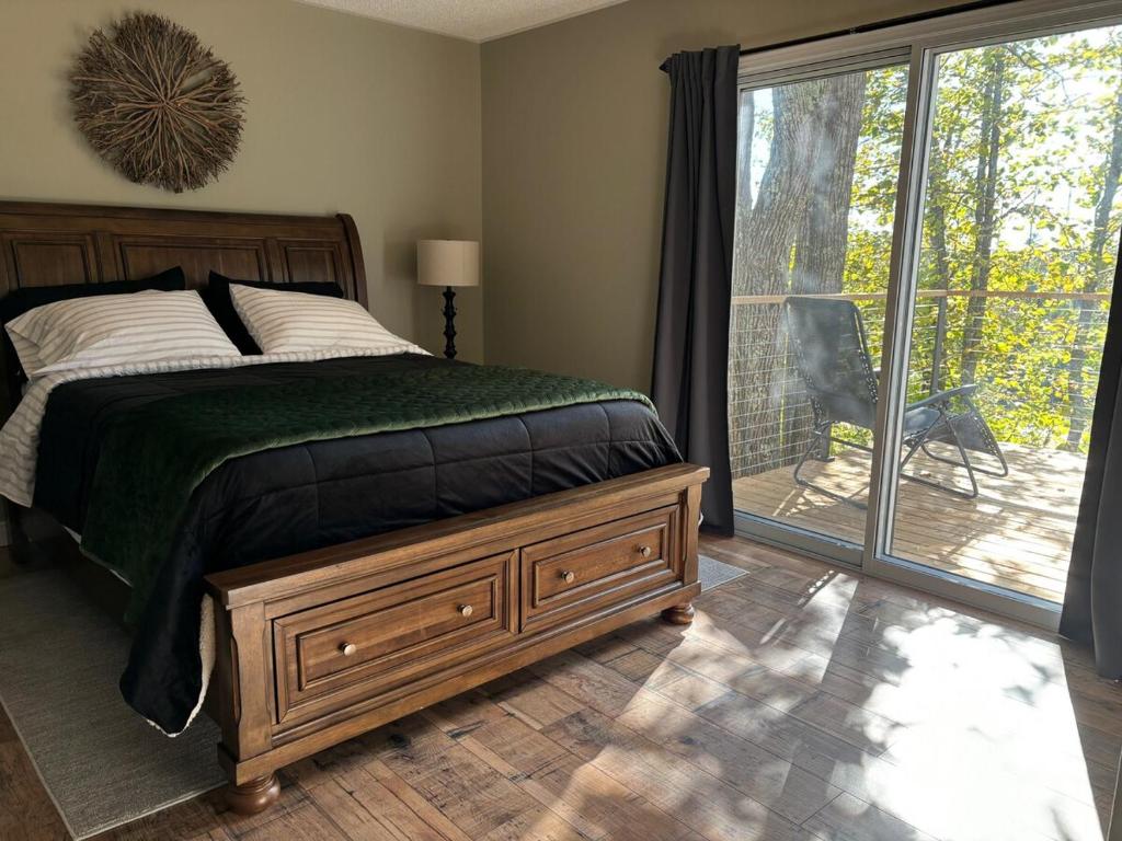 フォートフランシスにあるPeaceful Year Round Lakefront Getaway Nickel Lakeのベッドとガラスの引き戸のある寝室