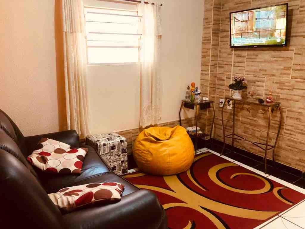 a living room with a couch and a large rug at Casa da Família Lima in Pirassununga