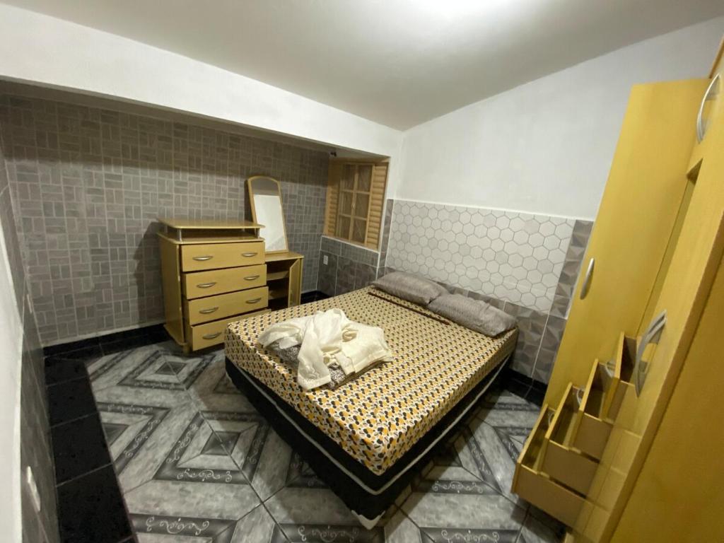 a small bedroom with a bed and a dresser at Casa da Família Lima in Pirassununga