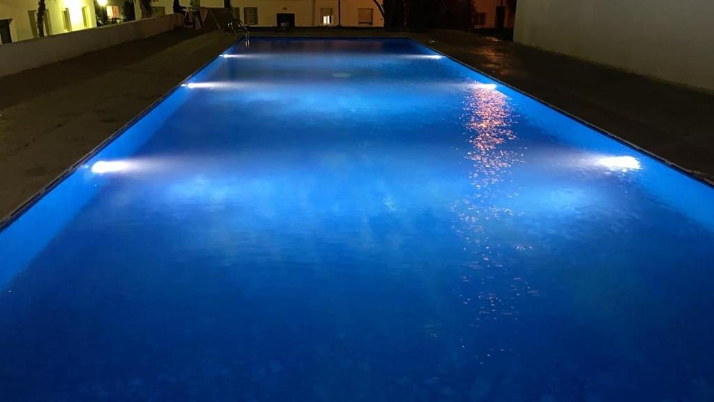 a swimming pool with blue lights on the floor at Appartement tangier airport in Hajreien