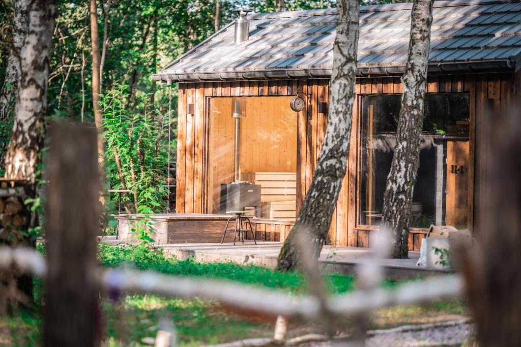 a wooden cabin with a porch in the woods at WieloHome in Wielogóra