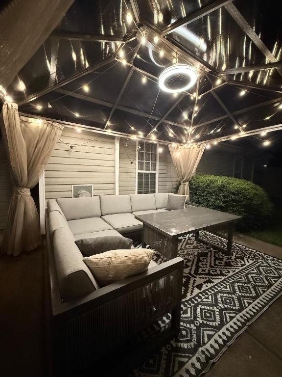 a patio with a couch and a table and lights at Queen City family-friendly entire house, Charlotte in Charlotte