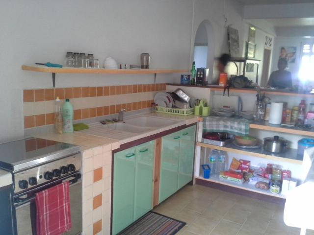 une cuisine avec un évier et une cuisinière dans l'établissement la mirabelle le vauclin, au Vauclin