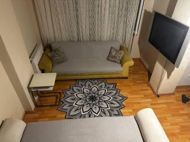 a living room with a couch and a flat screen tv at Green AirPort apart in Arnavutköy