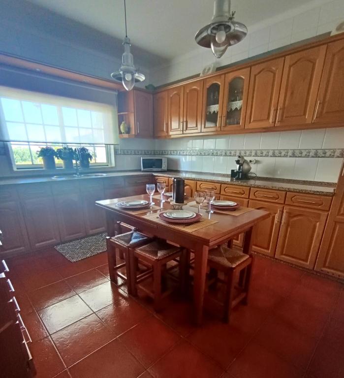 a kitchen with a wooden table with glasses on it at Recanto da Tia in Póvoa de Santa Iria
