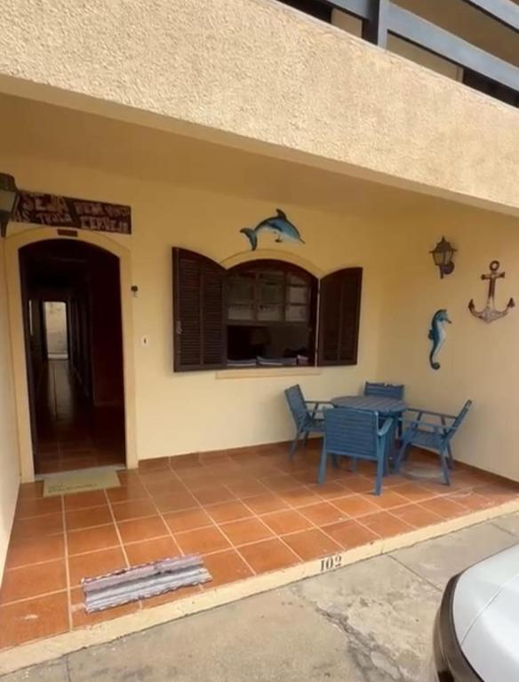 ein Haus mit einer Terrasse mit einem Tisch und Delfin-Aufklebern in der Unterkunft APT PERÓ Livio Viviani in Cabo Frio
