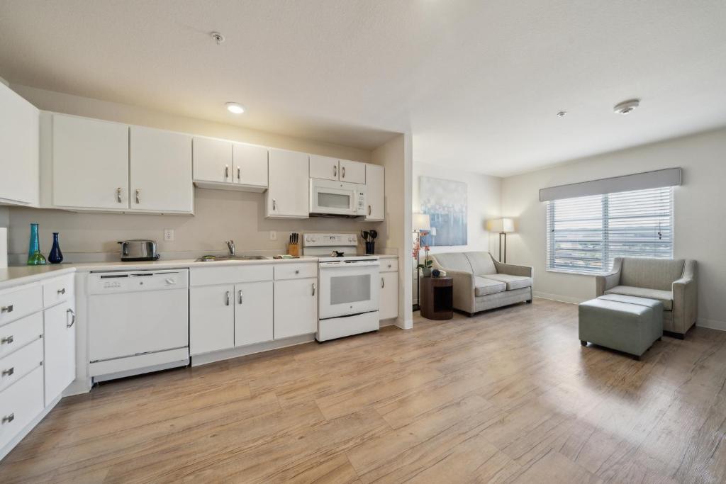 Una cocina con gabinetes blancos y una sala de estar. en Properties By Preston I 1bd1bth I Pool I Gym, en San Antonio