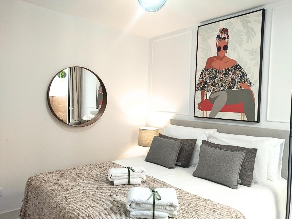 a bedroom with a large white bed with a mirror at Cais das Pedras Pátio Apartment - with washer and dryer machine in Porto
