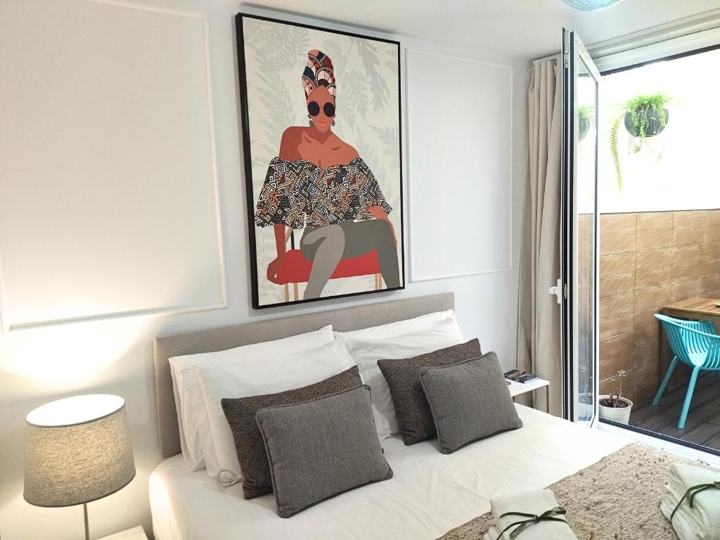 a bedroom with a bed with a painting above it at Cais das Pedras Pátio Apartment - washer-dryer machine in Porto