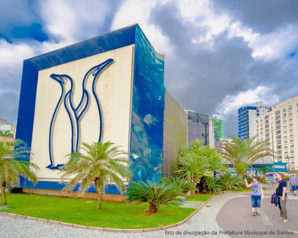 a mural on a building in a city with palm trees at Santos Prime Stay in Santos