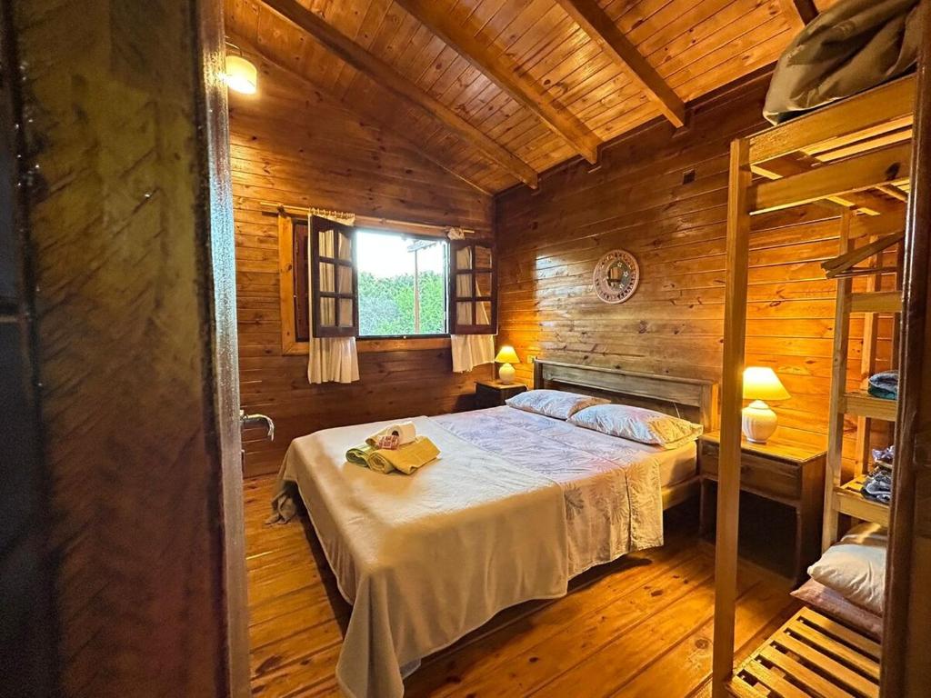 ein Schlafzimmer mit einem Bett in einer Holzhütte in der Unterkunft Cabaña turistica para huespedes! in La Falda