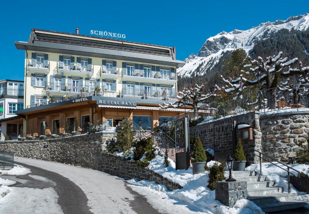 a hotel in the mountains with snow on the ground at Hotel Schönegg in Wengen