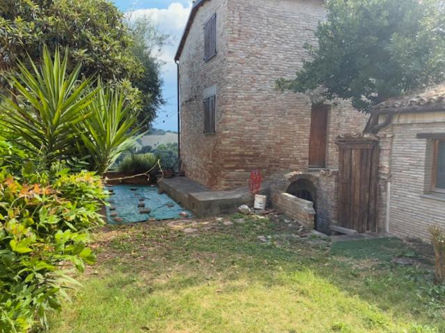 an old brick house with a brick oven in a yard at Da Luisa al Castello in Montemaggiore al Metauro