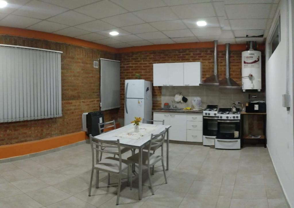 a kitchen with a table with chairs and a refrigerator at Departamento Saturnino in Neuquén