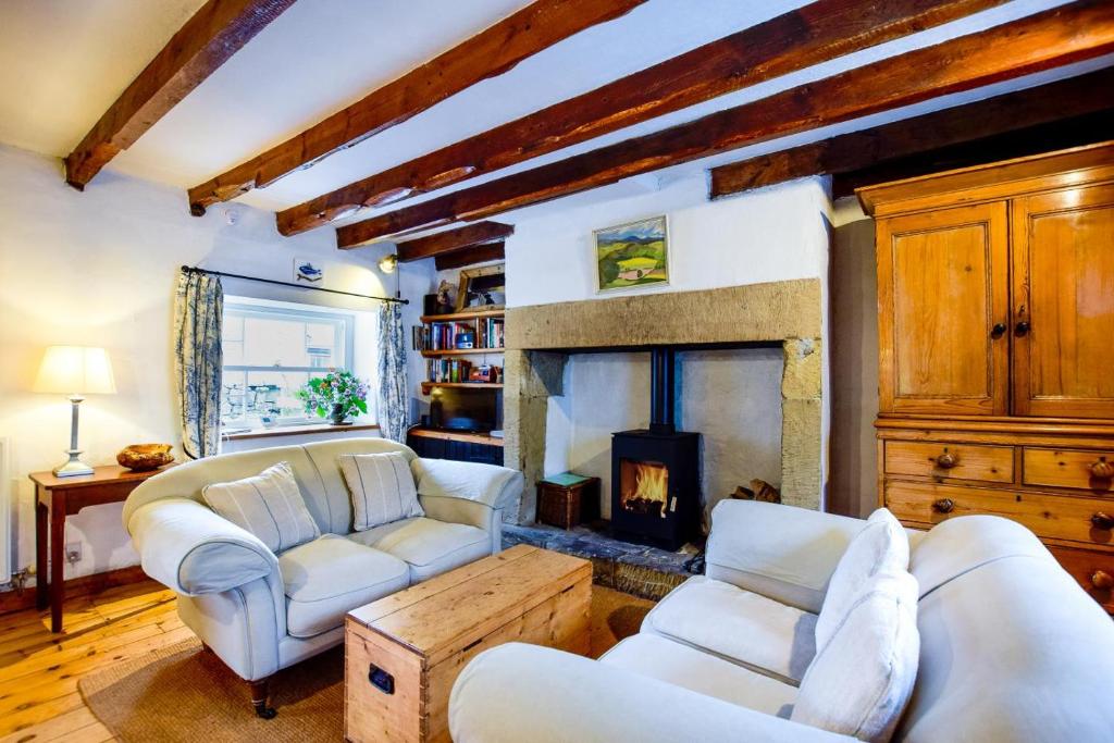 a living room with two couches and a fireplace at Mundles Cottage in Whittingham