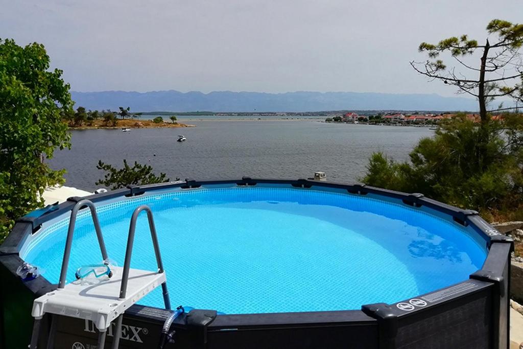 a large swimming pool next to a body of water at Seaside apartments with a swimming pool Nin, Zadar - 6153 in Nin