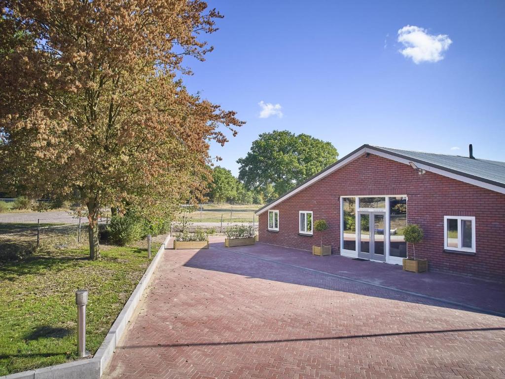 a red brick building with a large driveway at De Rouwenbogt in Hulsel