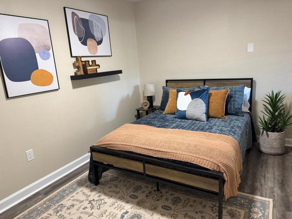 a bedroom with a bed with blue and yellow pillows at Swamp Side Stay in Gainesville