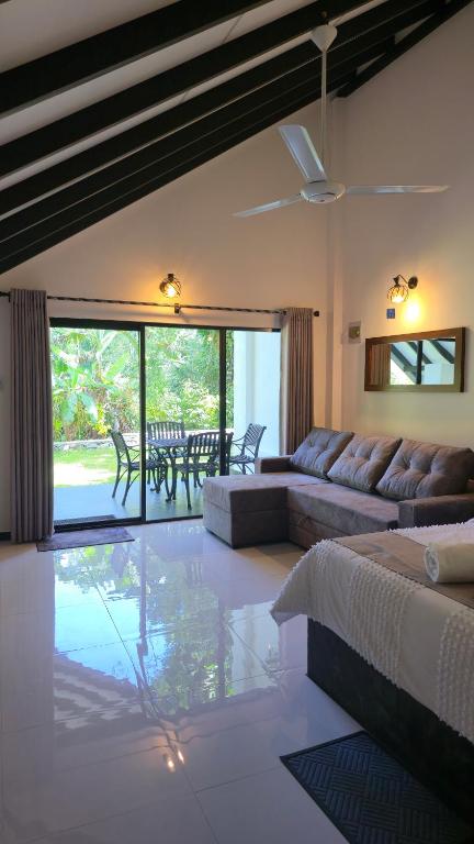 a living room with a couch and a table at Nildiya Cottages in Elpitiya