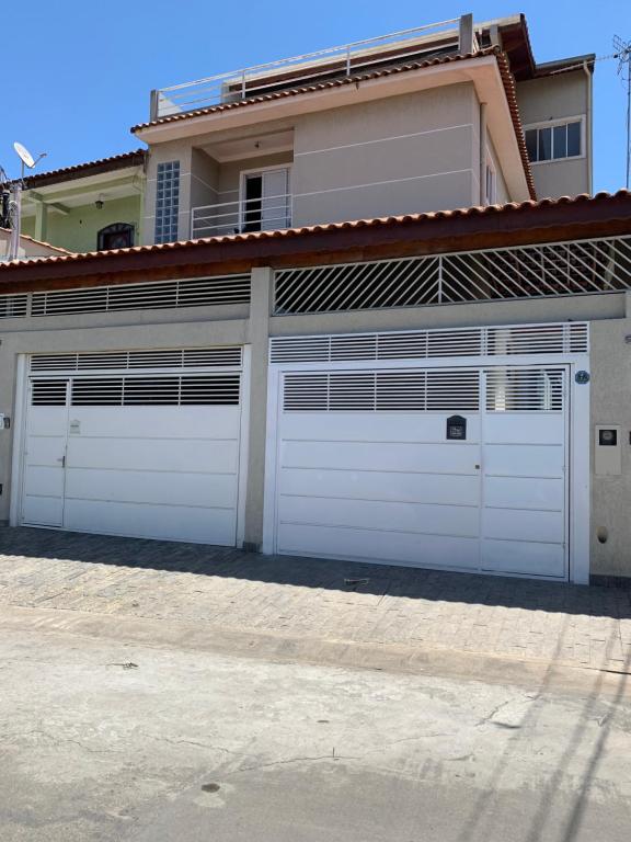 a house with white garage doors in front of it at Hostel GomaPass Guarulhos Aeroporto in Guarulhos