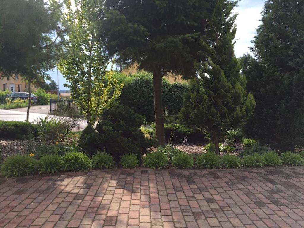 a brick walkway with trees and bushes in a park at Dreamtime2 Fam Zimmermann in Balm
