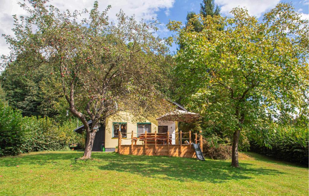 a small house in the middle of a yard with trees at Ferienhaus In Ruhiger Lage in Friedberg