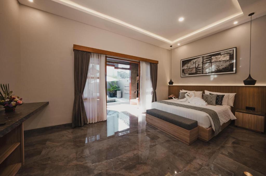 a bedroom with a bed and a sliding glass door at Dikubu Belong VILLA in Denpasar