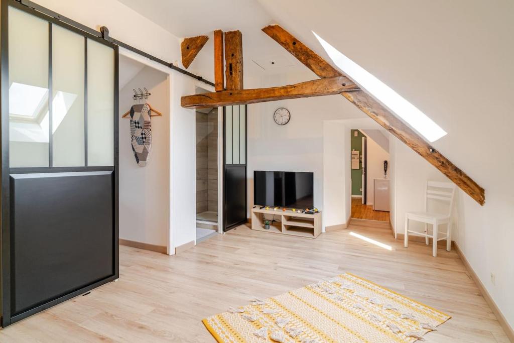 a living room with a large glass door and wooden beams at Bienvenue chez Marie et Guillaume in Carentan