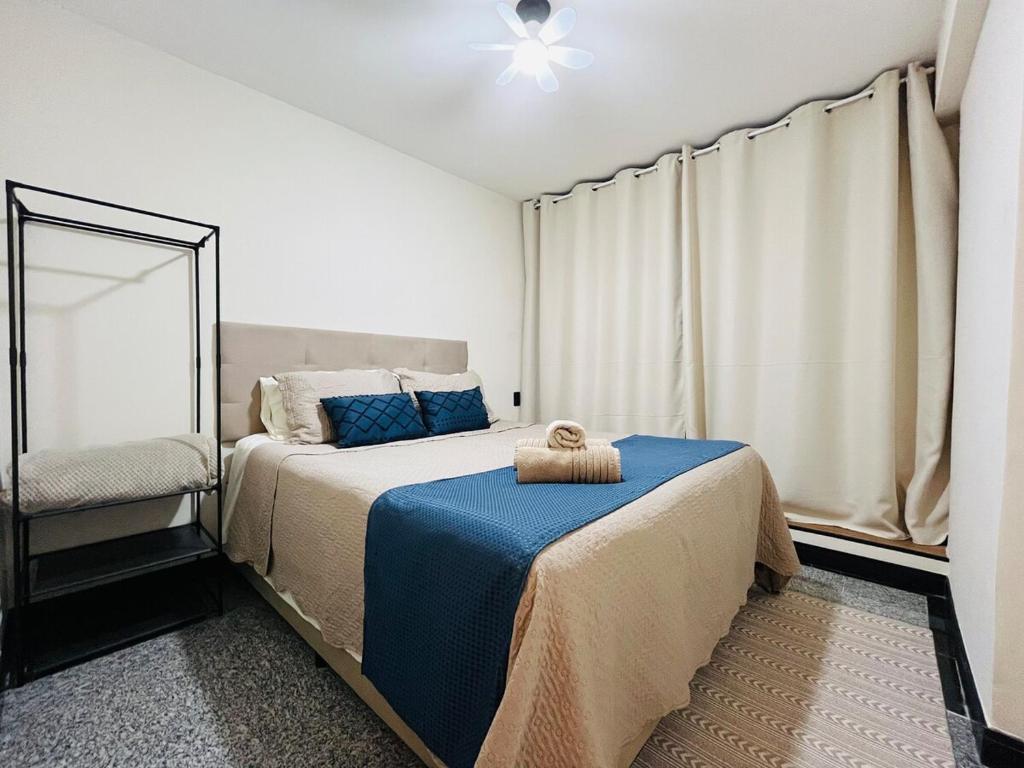 a bedroom with a bed with a blue blanket at Studio Aconchego - 2 Bedrooms with Wi-Fi Subway in Sao Paulo