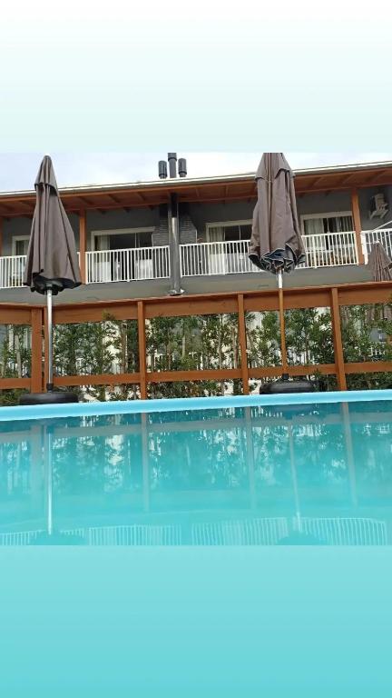 a building with a swimming pool with two umbrellas at Seven76Residence in Barra Velha
