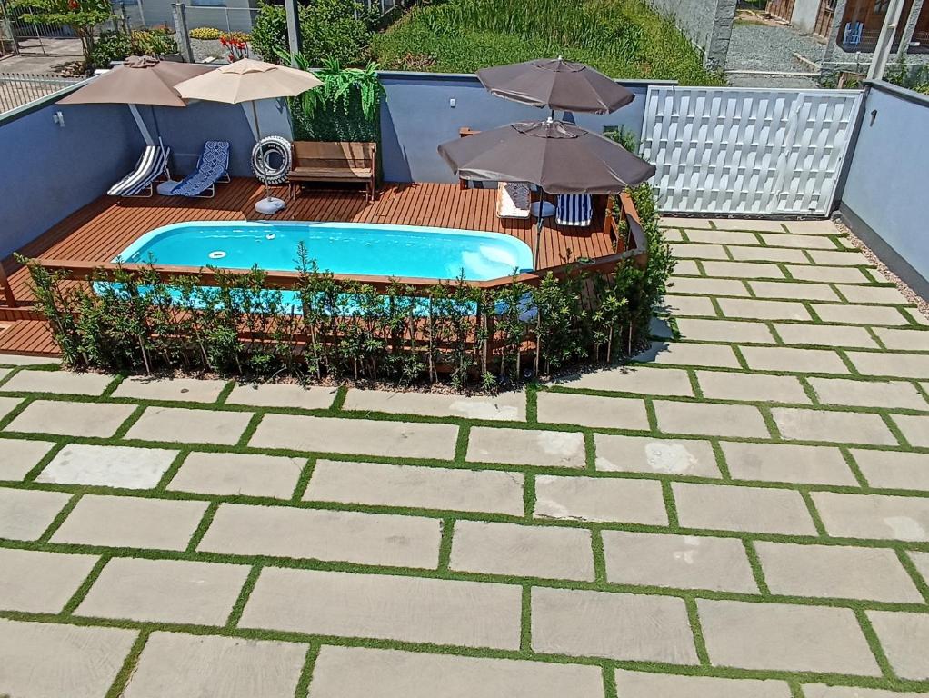 een zwembad met parasols op een patio bij Seven76Residence in Barra Velha