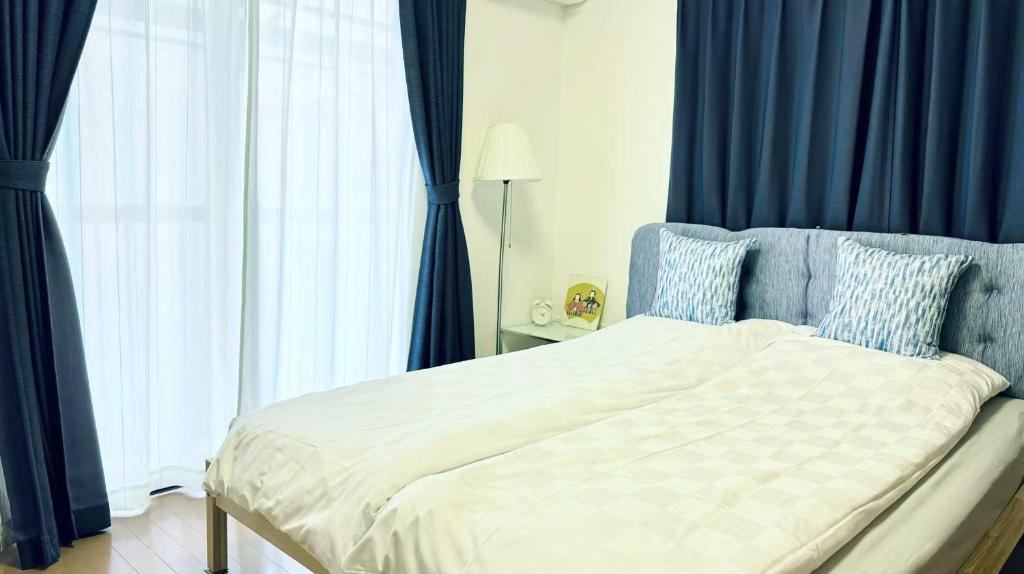 a bedroom with a bed with blue drapes at 夏様香驛 Historic Kyoto Villa, 4LDK Private House, Perfect for Families in Kyoto